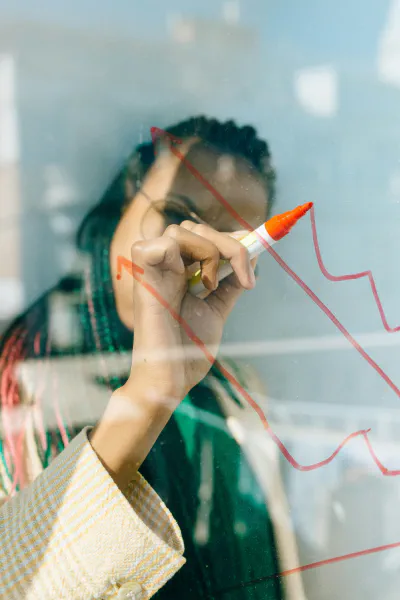 A woman draws on a white board